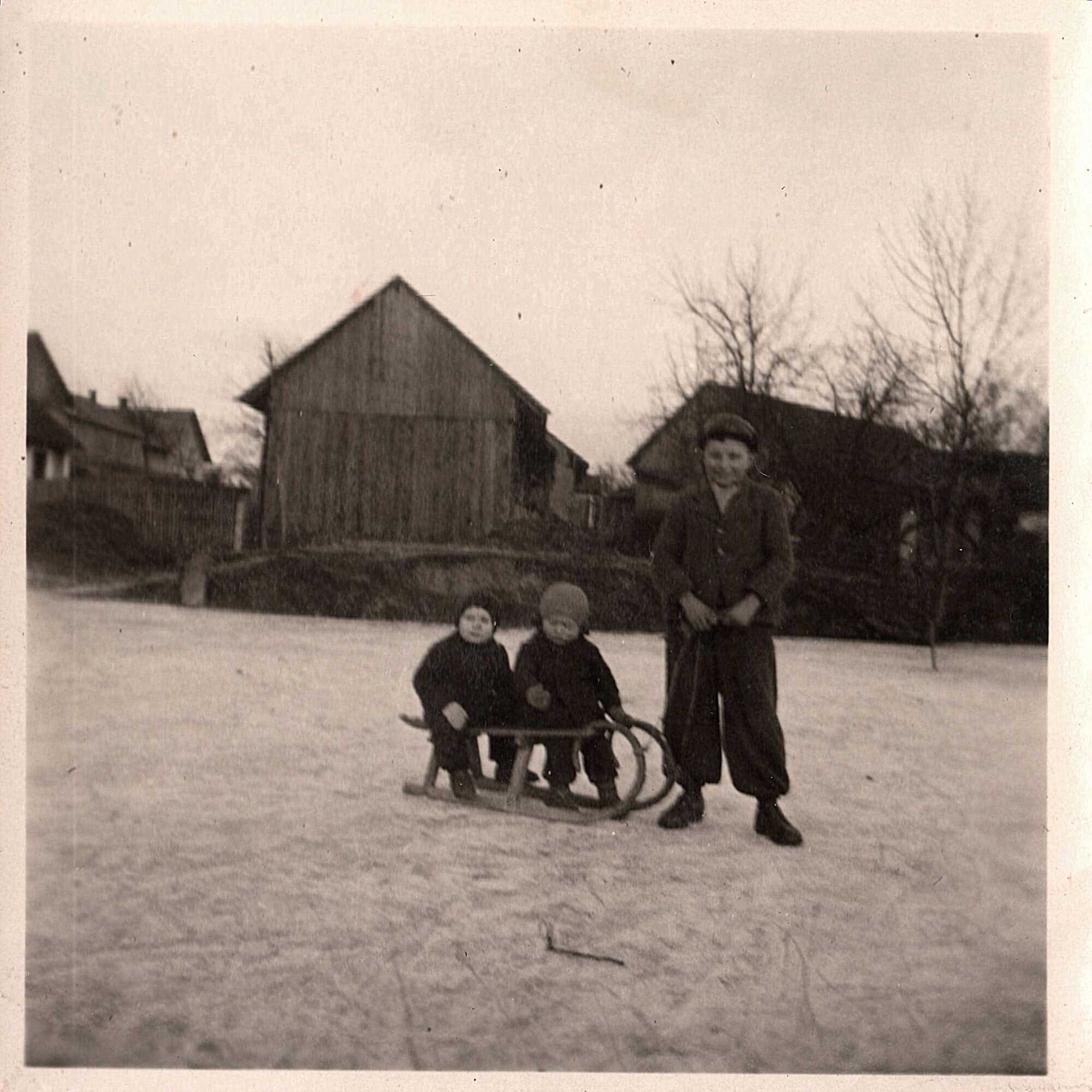 Na Loužičáku za Endrlovic stodolou Karel Pecha a dvě děti na saních